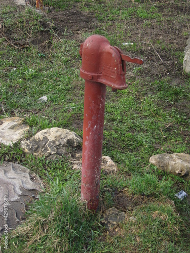 iron hydrant of red color for water intake from a well