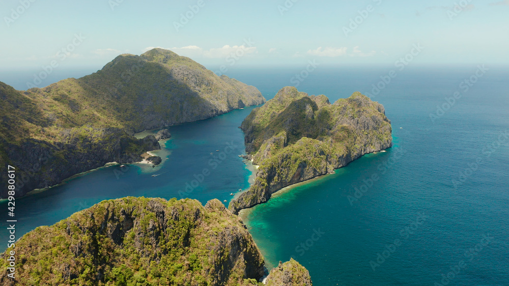 Obraz premium Bay and the tropical islands. Seascape with tropical rocky islands, ocean blue wate, aerial view. islands and mountains covered with tropical forest. El nido, Philippines, Palawan. Tropical Mountain