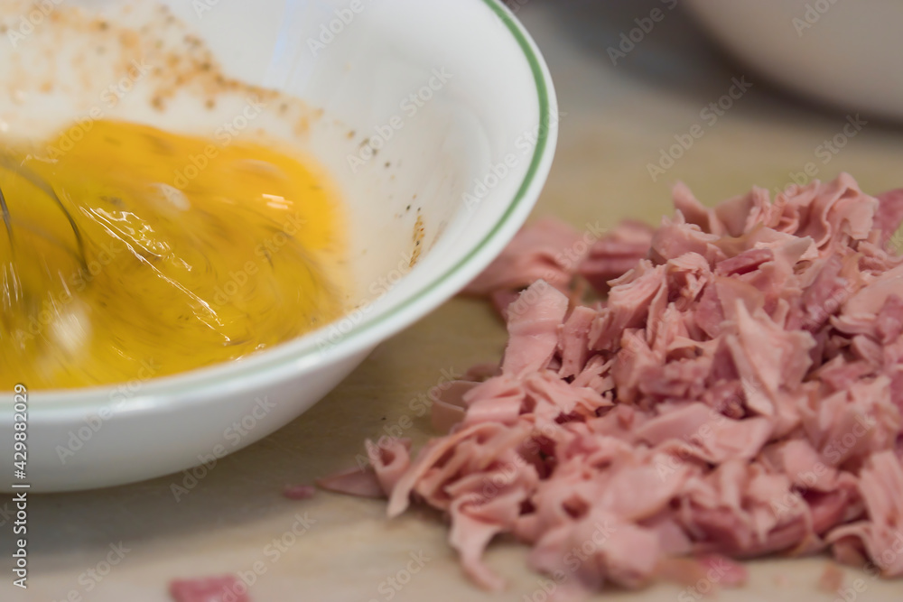 rapidly stirring raw eggs in a bowl with a whisk rapidly stirring raw eggs in a bowl with a whisk