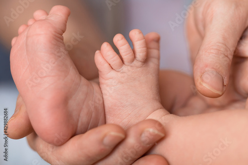 close up: newborn baby feet in a hand of mother