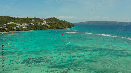 Fototapeta Naklejka Na Ścianę i Meble -  Tropical beach with turquoise water with kite-surfer rides, aerial view. Kitesurfing on a tropical island. Boracay, Philippines