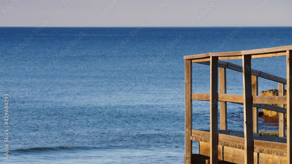 Spanish sea shore with wooden boardwalk. Seaside landscape, mediterranean sea.