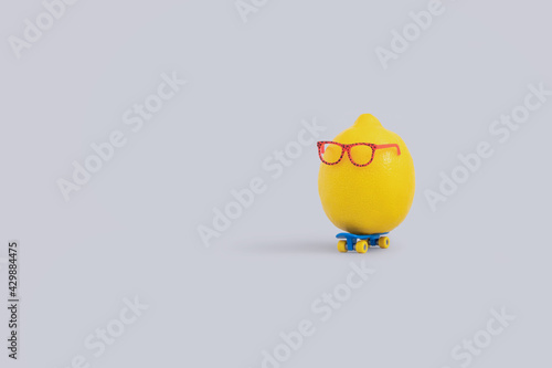 Funny creative food concept with lemon wearing eyeglasses and riding skateboard photo