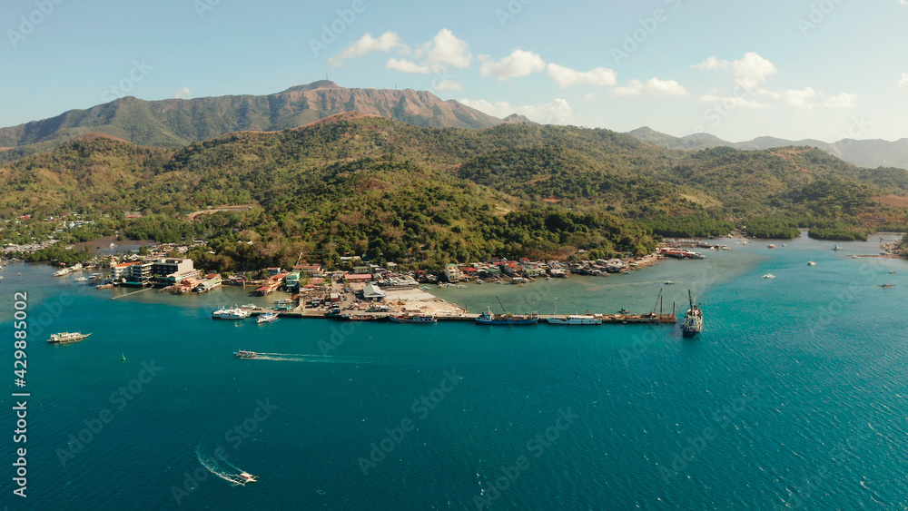 aerial view ferry port in the city of Coron, on the island Busuanga, Philippines.Ferries transport vehicles and passengers in port . Passenger and cargo port with ships.