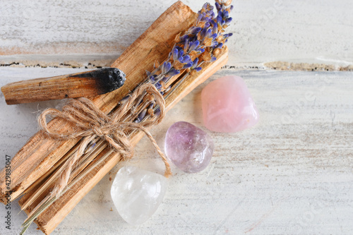 A close up image of holy wood incense sticks with healing rose quartz and amethyst crystals.  photo