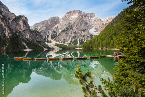 Mount Seekofel and boats in the evening light, mirroring in the clear calm water  of iconic mountain lake Pragser Wildsee (Lago di Braies) in Dolomites, Unesco World Heritage, South Tyrol, Italy photo