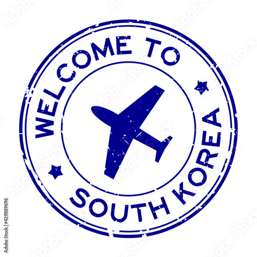 Grunge blue welcome to South Korea word with airplane icon round rubber seal stamp on white background