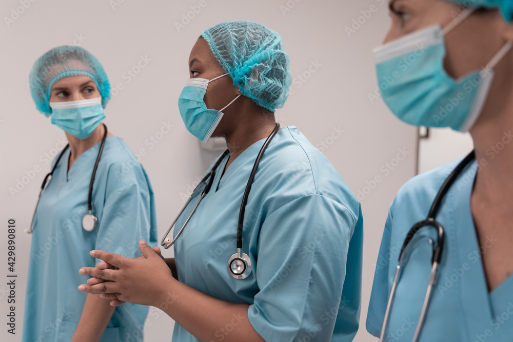 Portrait of diverse group of male and female doctors standing in operating theatre Portrait of diverse group of male and female doctors standing in operating theatre