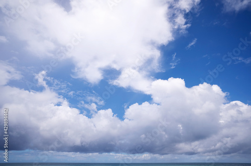 White cumulus clouds in sky over blue sea water landscape  big white cloud above ocean sea surface horizon Beautiful tropical sunny summer day seascape Good weather day
