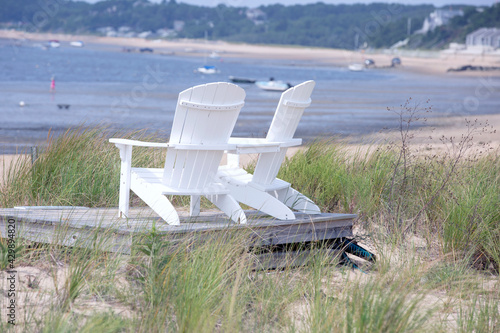 Two wooden beach chairs at the shore on Cape Cod in Wellfleet MA