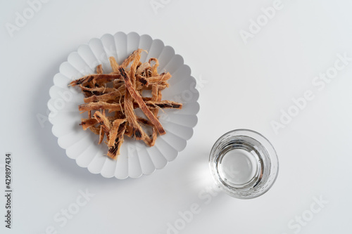 白い背景で撮影された酒とおつまみ（あたりめ
