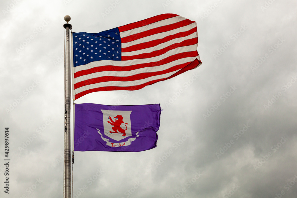 Flags of the United States of America and Talbot County, Maryland are flying together on a flag post against cloudy sky. Isolated image with copy space Flags of the United States of America and Talbot County, Maryland are flying together on a flag post against cloudy sky. Isolated image with copy space