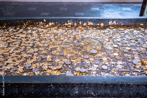 The tradition of throwing coins and sticking gold foil on sacred objects to bring luck in Thailand,A pieces of gold foil texture stick together. Golden background and texture.