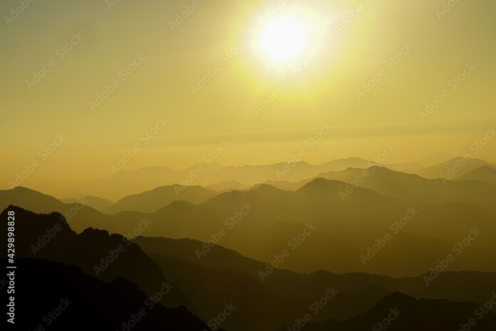 Mountain ridge on Huangshan mountain,Nature landscape view of Beautiful sunset sky above clouds with dramatic light,Sunshine background landscape scene,View of mountains and valley on silhouette sun. Mountain ridge on Huangshan mountain,Nature landscape view of Beautiful sunset sky above clouds with dramatic light,Sunshine background landscape scene,View of mountains and valley on silhouette sun.
