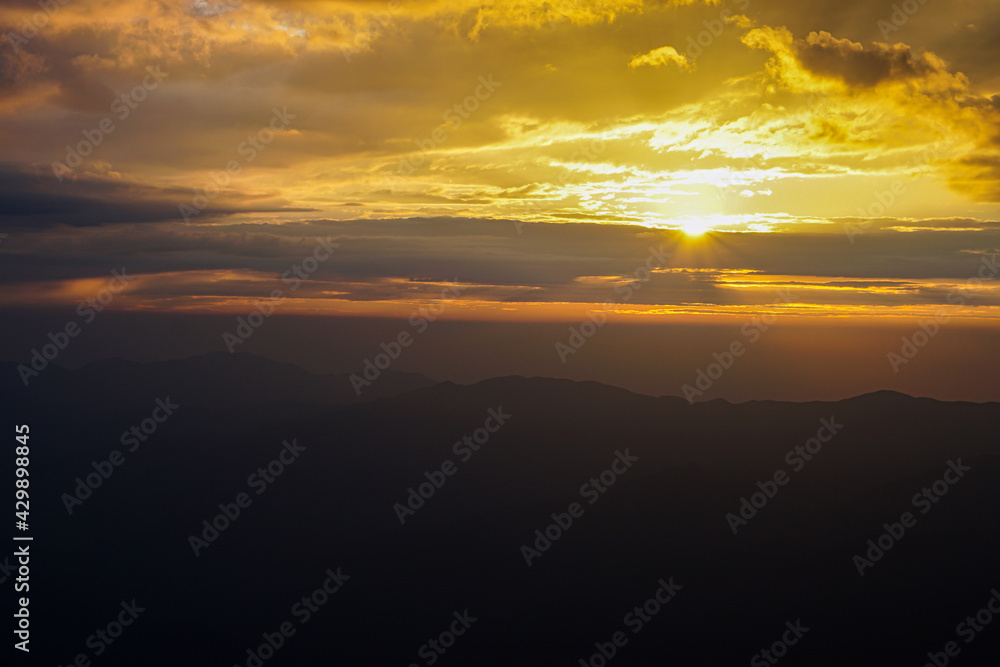 Mountain ridge on Huangshan mountain,Nature landscape view of Beautiful  sunset sky above clouds with dramatic light,Sunshine background landscape scene,View of mountains and valley on silhouette sun.