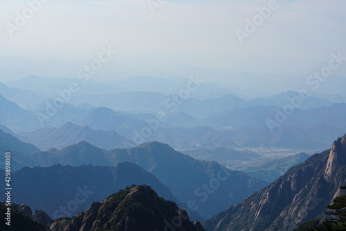 View from the mountain top over foggy HuangSan Mountain with wild pine tree forest,heavy dramatic clouds,Huangshan mountains, also known as the yellow mountains, Anhui province, China