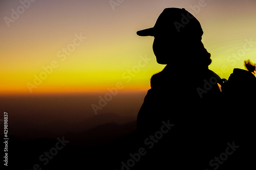 Silhouette of a person watching the sunset in the mountains