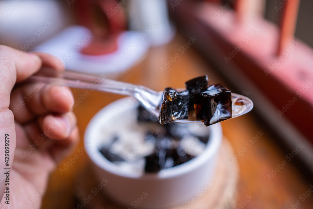 Grass jelly dessert herbal gelatin or jelly black with pineapple, syrup, ice, and brown sugar on the wooden background. Chinese style. Grass jelly dessert herbal gelatin or jelly black with pineapple, syrup, ice, and brown sugar on the wooden background. Chinese style.