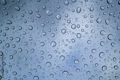 Water drops on glass of car sunroof with copy space,Rain drops on SUV glass panoramic sunroof. Abstract irregular water drops background with seamless pattern.