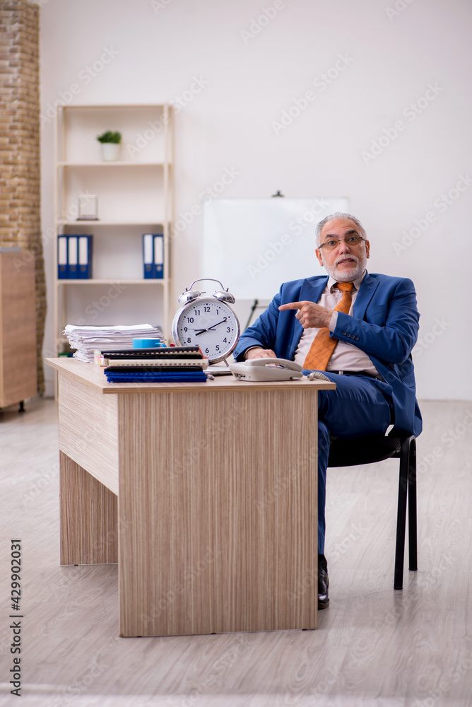 Old businessman employee in time management concept Old businessman employee in time management concept