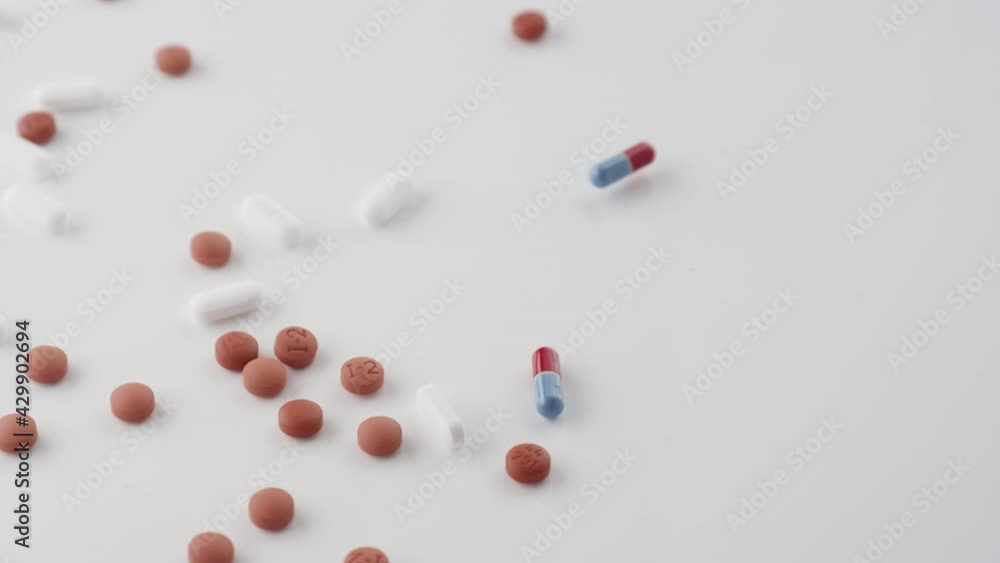 Slow motion shot of a mix of prescription pills spilling onto a table Slow motion shot of a mix of prescription pills spilling onto a table
