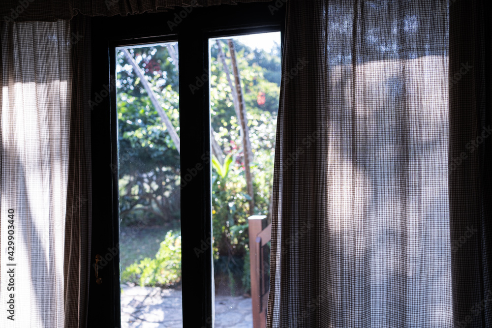 Window with curtains,Window with a view onto fields and trees in a rural setting. Curtains and a bright summers day make this a beautiful scene,opening window curtains,Curtain interior decoration. Window with curtains,Window with a view onto fields and trees in a rural setting. Curtains and a bright summers day make this a beautiful scene,opening window curtains,Curtain interior decoration.