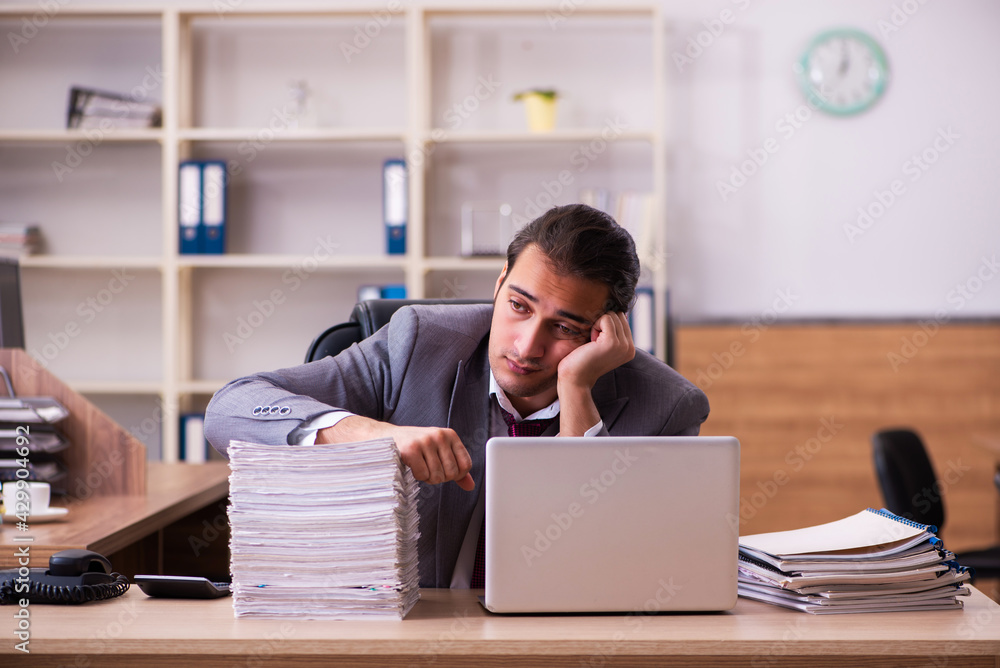 Young male employee extremely tired with excessive work Young male employee extremely tired with excessive work