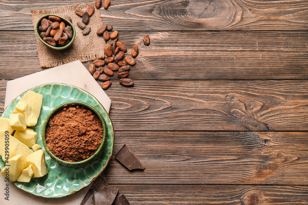 Composition with cocoa powder, beans, butter and chocolate on wooden background Composition with cocoa powder, beans, butter and chocolate on wooden background