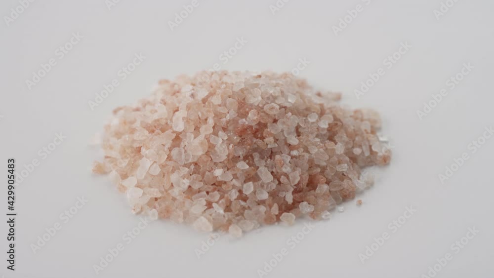 A pile of himalayan pink sea salt rotating on white A pile of himalayan pink sea salt rotating on white