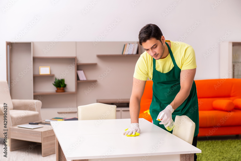Young male contractor cleaning the house indoors Young male contractor cleaning the house indoors