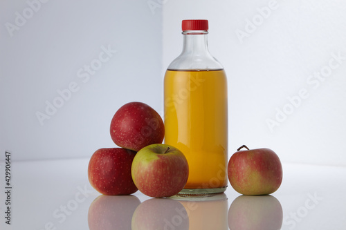 apple cider vinegar and fresh apples on white background