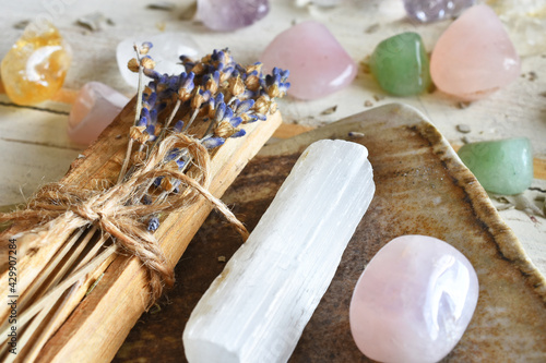 A close up image of Palo Santo incense sticks with dried lavender and healing crystals on a white background.  photo