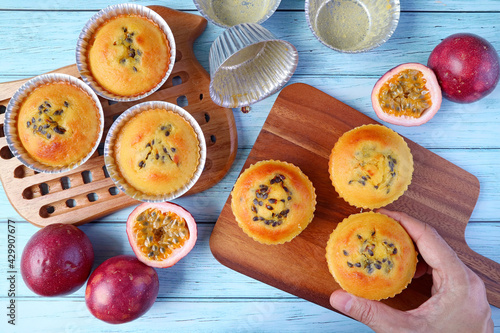 Wallpaper Mural Hand Placing Fresh Baked Homemade Passion Fruit Muffins on Breadboard after Taking from the Molds Torontodigital.ca