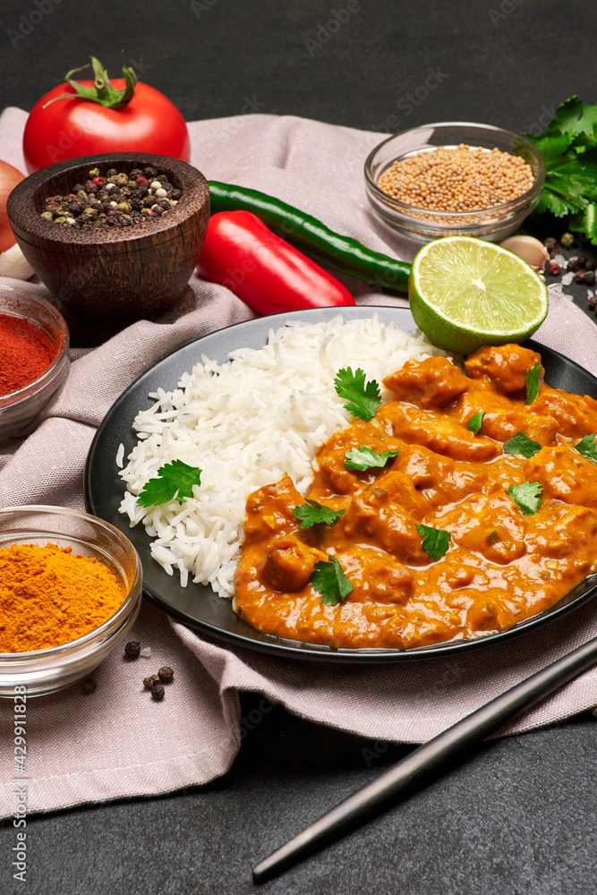 Plate of Traditional Chicken Curry, rice and spices on dark concrete background Plate of Traditional Chicken Curry, rice and spices on dark concrete background