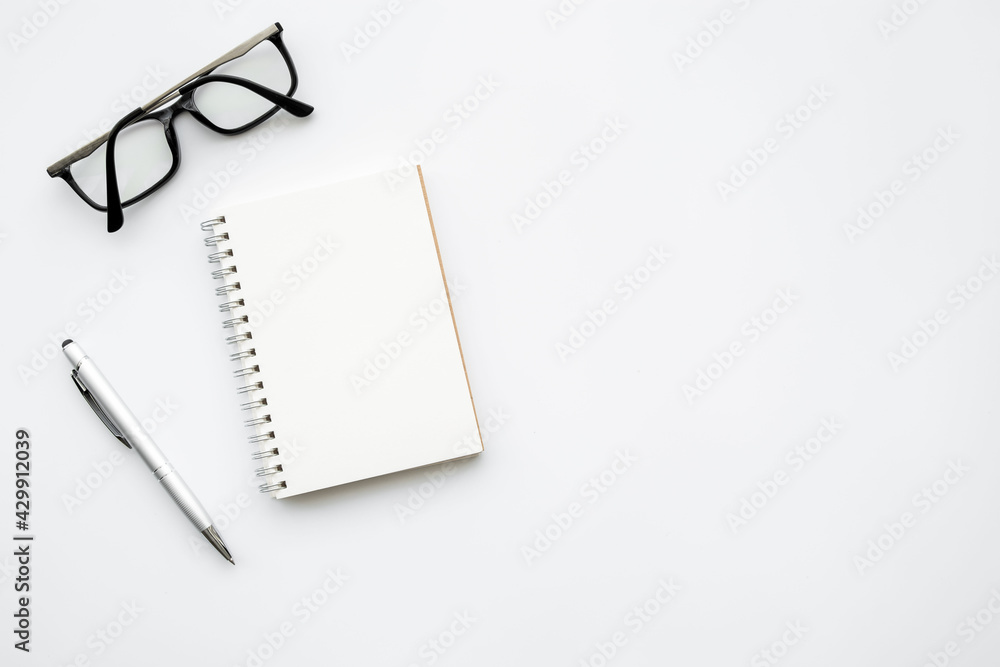 Blank notebook with pen are on top of white office desk table. Top view with copy space, flat lay. Blank notebook with pen are on top of white office desk table. Top view with copy space, flat lay.