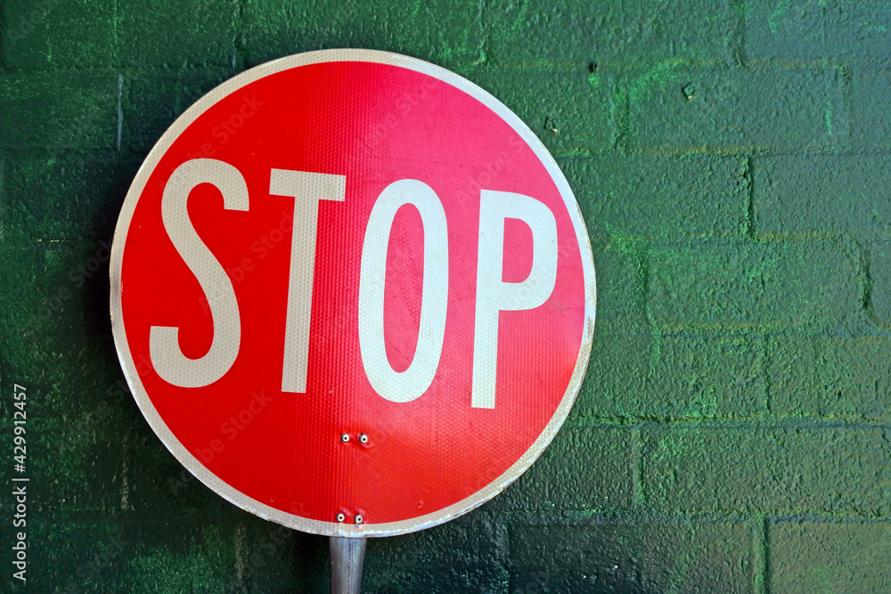 Traffic stop sign leaning on brick wall Traffic stop sign leaning on brick wall