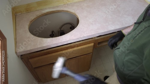 Man uses sledgehammer to remove bathroom countertop