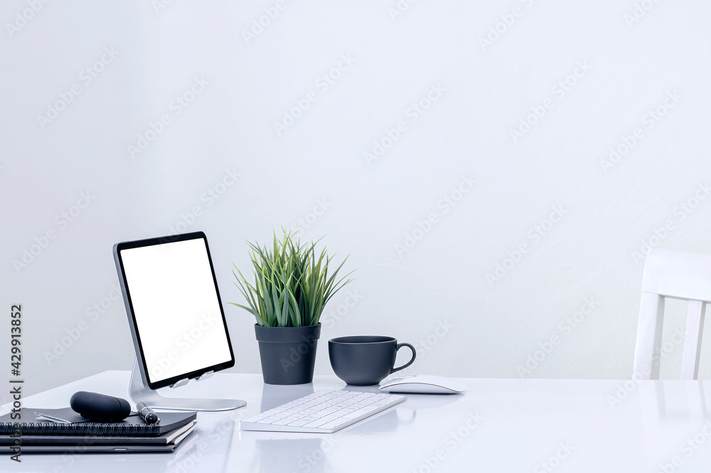 Mockup blank screen tablet on stand holder with keyboard on white table in white room. Mockup blank screen tablet on stand holder with keyboard on white table in white room.