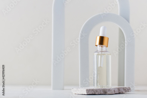 Serum or oil for facial skin care. Cosmetic care product in a glass shade on the background of arches. Copy space.