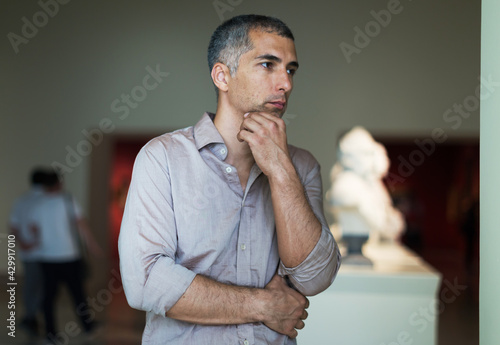 Man is looking at the exposition in the picture gallery.