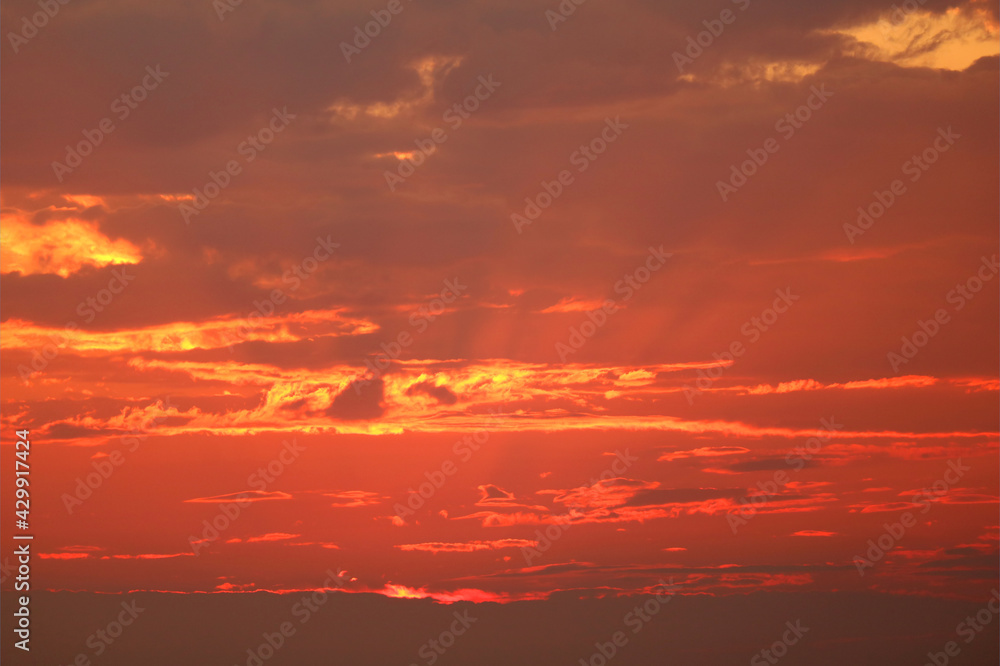 God Rays or Crepuscular Rays on the Gorgeous Golden Red Sunset sky
