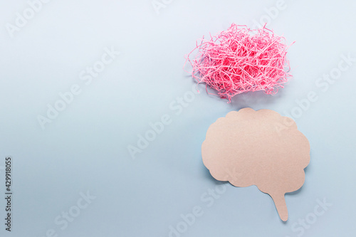 Simple thinking overthinking concept made with real paper brain outline and shredded pin paper cloud on blue background photo