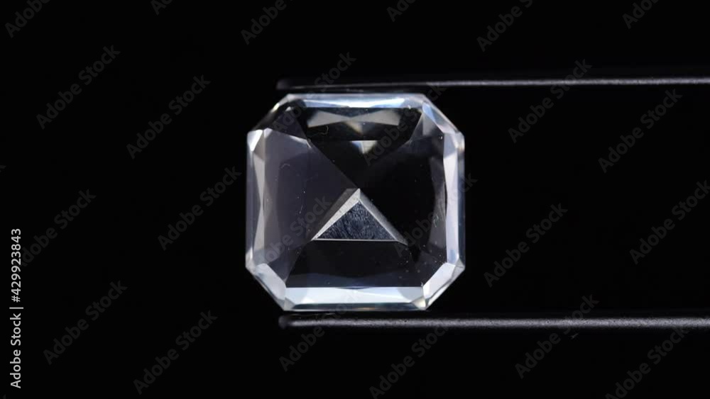 natural white quartz gemstone in tweezer on the turning table natural white quartz gemstone in tweezer on the turning table