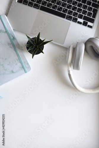 white headphones laptop headphones on the table flat lay photo