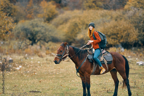 woman hiker in the mountains riding a horse travel lifestyle