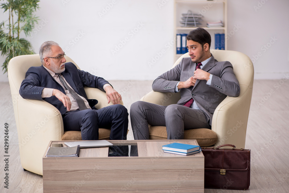 Two businessmen discussing project at workplace Two businessmen discussing project at workplace