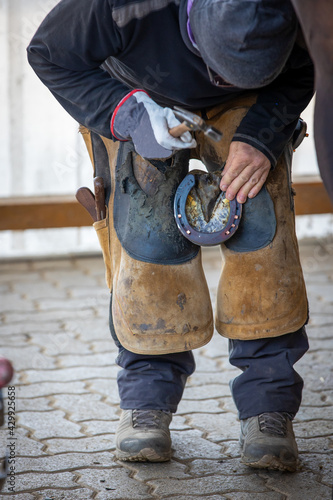 Farrier nailing a horseshoe, focus on the hoof..