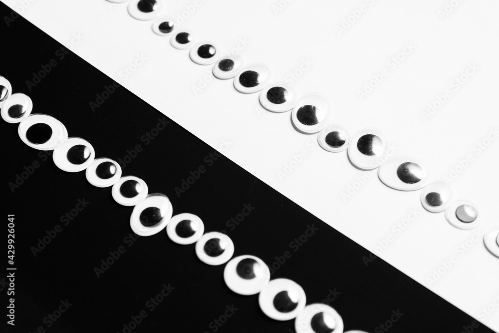 Toy eyes laid out on black and white hermetic background Stock Photo