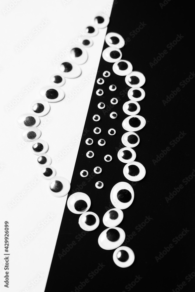 Toy eyes laid out on black and white hermetic background Stock Photo