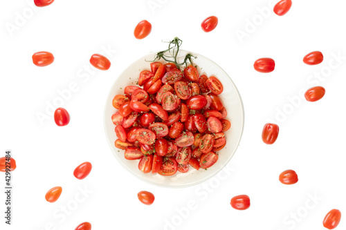tomatoes cherry on plate with spicery on a table, white background, composition